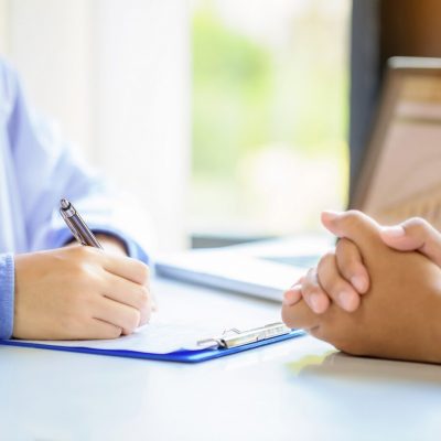 doctor-man-consulting-patient-while-filling-up-application-form-desk-hospital_1150-12965